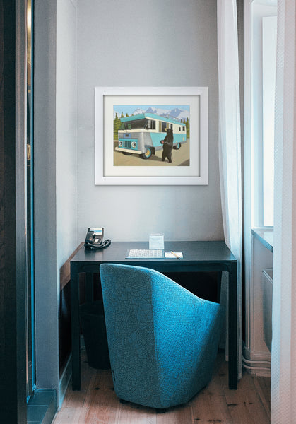 Picture of a Vintage 1963 Condor RV in the Mountains with a Bear Panhandling with a Tim Horton's Cup in Hand framed hanging on wall above a small desk