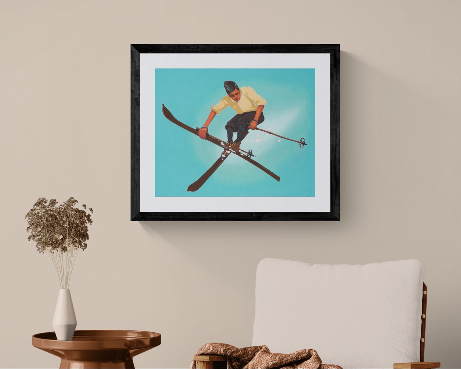 Framed artwork of a person on skis hanging on a wall above a chair and table.