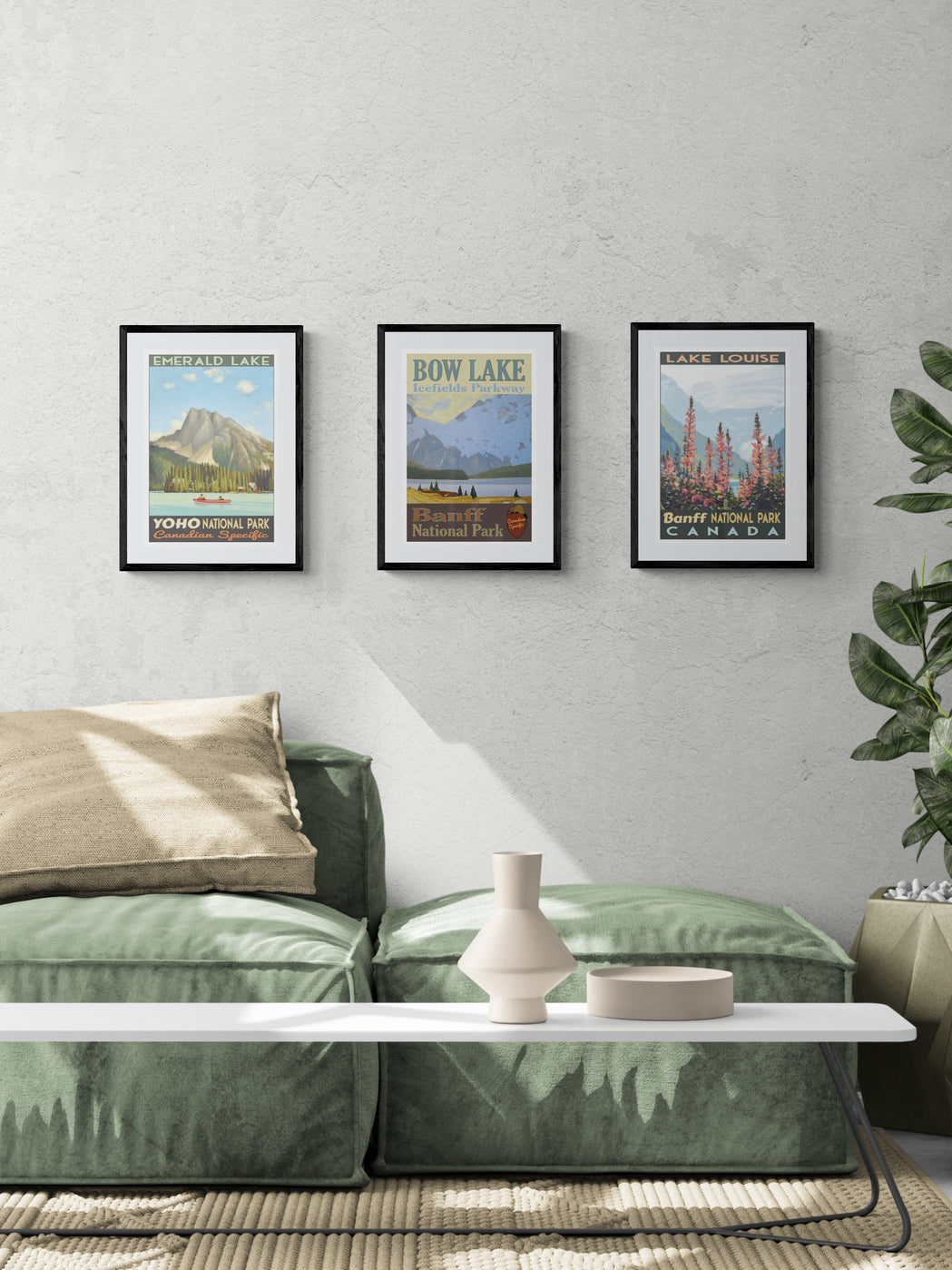 Green sofa in a living room with framed landscape posters on the wall.