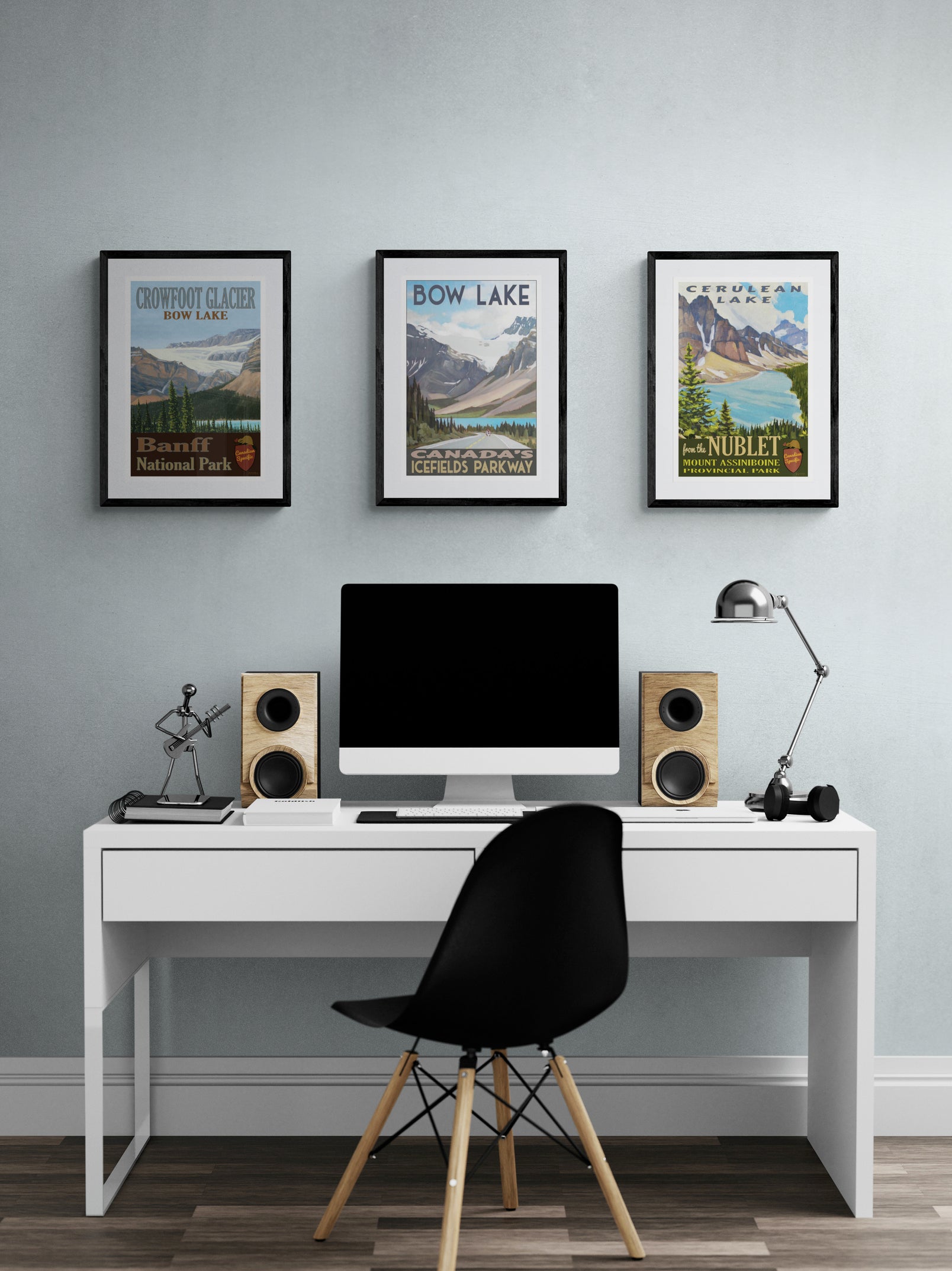 Modern home office with a desk, computer setup, and three framed landscape prints on the wall.