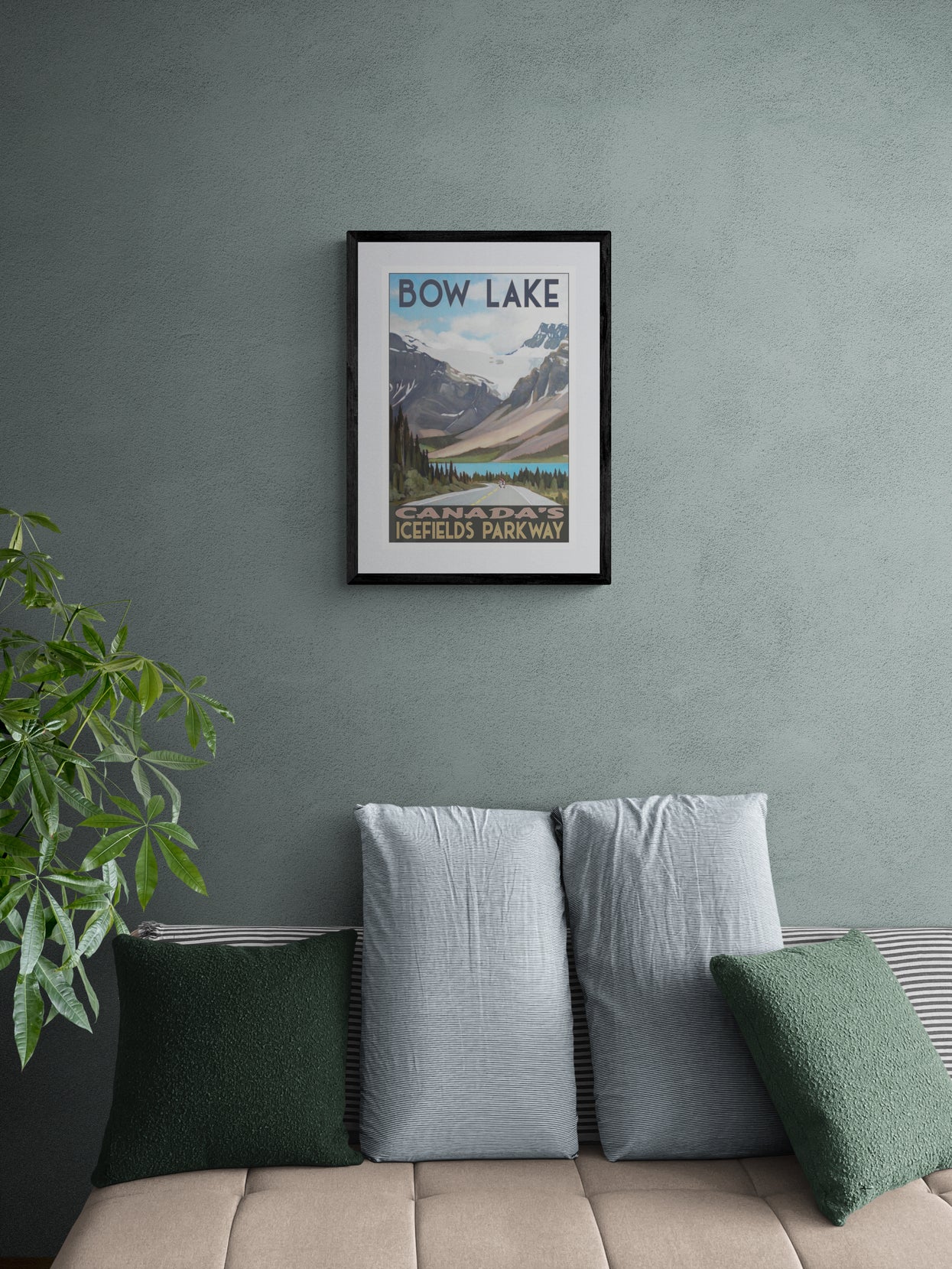 Framed poster of Bow Lake, Alberta on a wall above a sofa with decorative pillows.