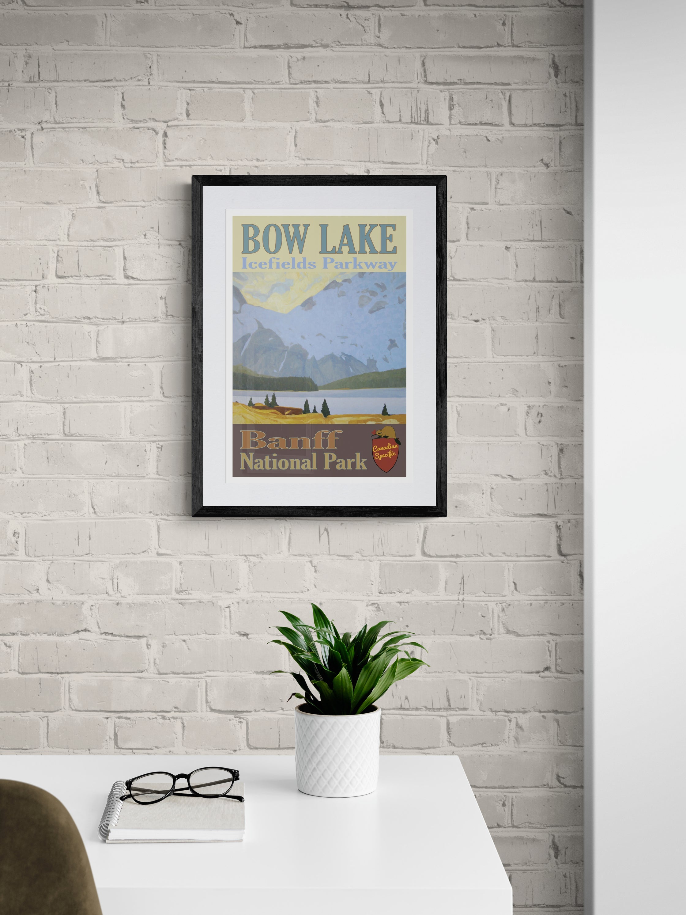 Framed poster of Bow Lake, Banff National Park on a white brick wall.